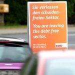 The CDU's Dusseldorf branch has raised some eyebrows with this poster imitating the old check point signs of when Germany was divided, but describing their country as the "debt free sector". Photo: DPA