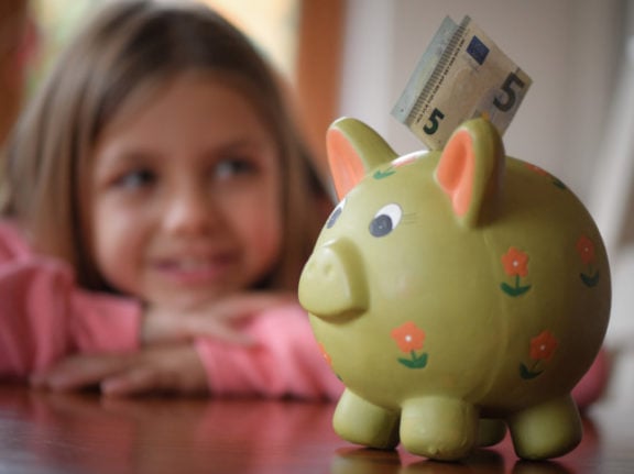 A young girl with a piggy bank