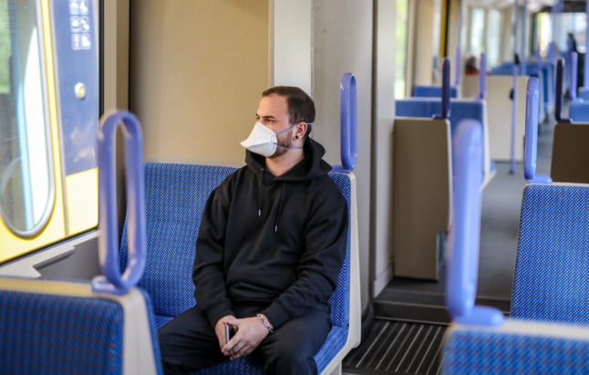 A man wears a medical mask on a local train in Stuttgart