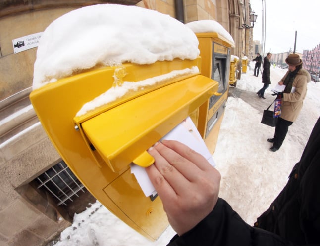 A man posts a letter in the snow in Magdeburg