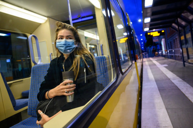 A woman in a mask sits on a Stuttgart train