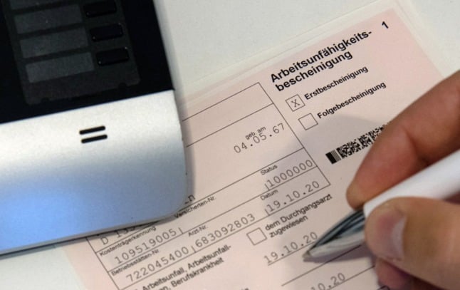 A doctor signs an incapacity to work slip in Germany. 