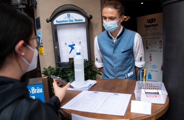 A restaurant worker checks a Covid health pass in Munich in August