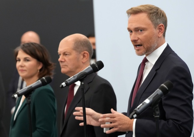 The Greens' Annalena Baerbock, the SPD's Olaf Scholz and the FDP's Christian Lindner talk at a press conference on Friday.