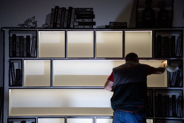 A man cleans shelves at the reopening of the Frankfurt Book Fair