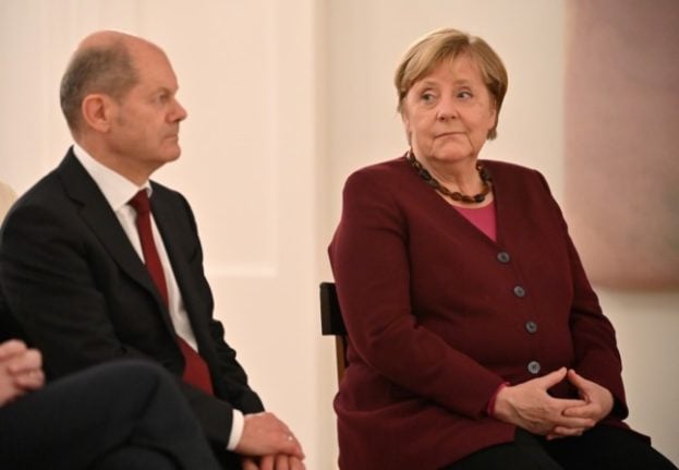 SPD chancellor candidate Olaf Scholz with chancellor Angela Merkel as she received her certificate of discharge on Tuesday. 