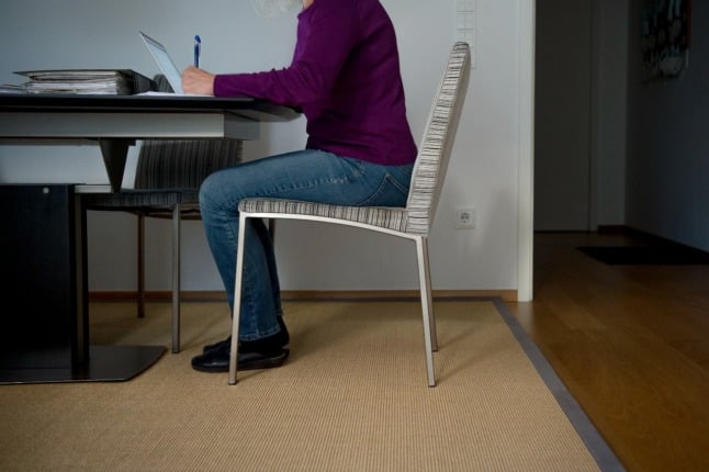 A woman sits at her desk at home in Munich