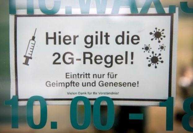 A sign in front of a waxing studio in Berlin indicates the rule of the 2G system