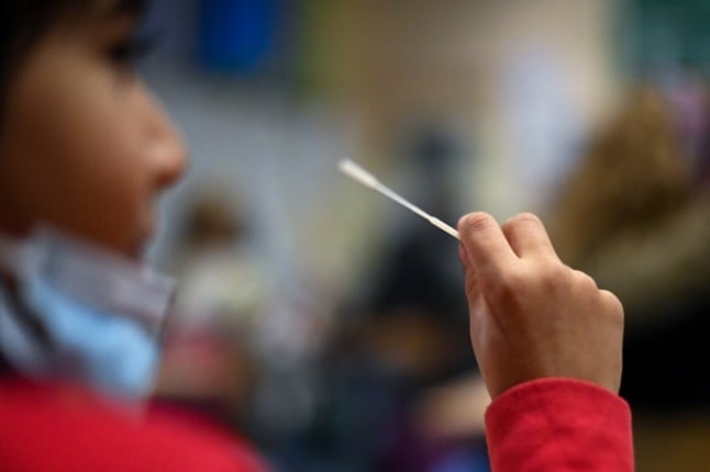 A boy of a school class takes his sample for the so-called 'lollipop test'