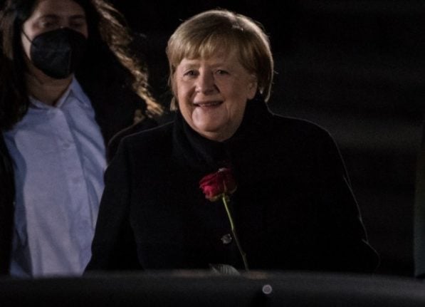 German Chancellor Angela Merkel holds a red rose as she leaves the Defence Ministry during the Grand Tattoo (Grosser Zapfenstreich) in Berlin