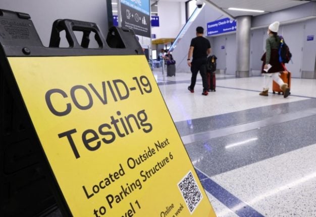  sign promotes a COVID-19 testing location located inside the Tom Bradley International Terminal at Los Angeles