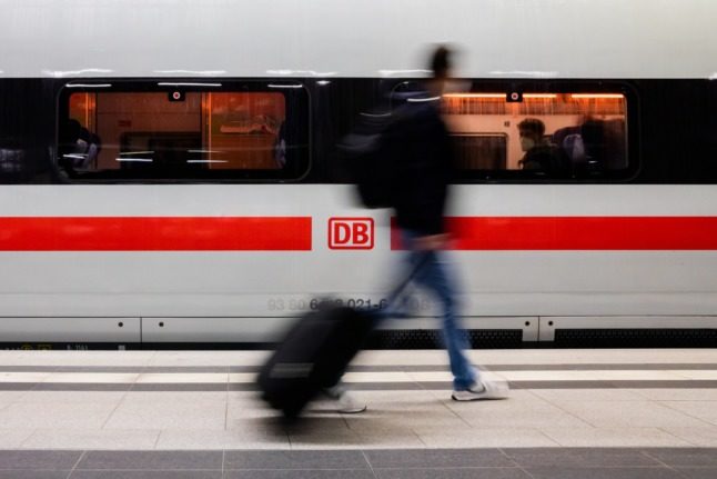 A passenger walks past a high speed train at Berlin central station