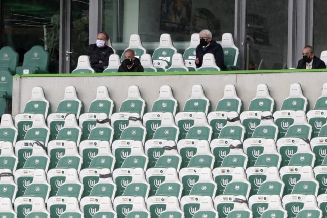 Borussia Dortmund CEO Hans-Joachim Watzke (L), wearing a face mask, watches a German Bundesliga football match