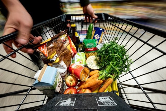 A shopper holds a trolley at a Berlin supermarket.
