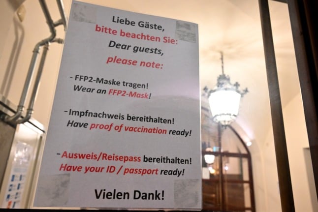 A Munich guesthouse with a sign asking people to have their vaccination pass and ID ready. 