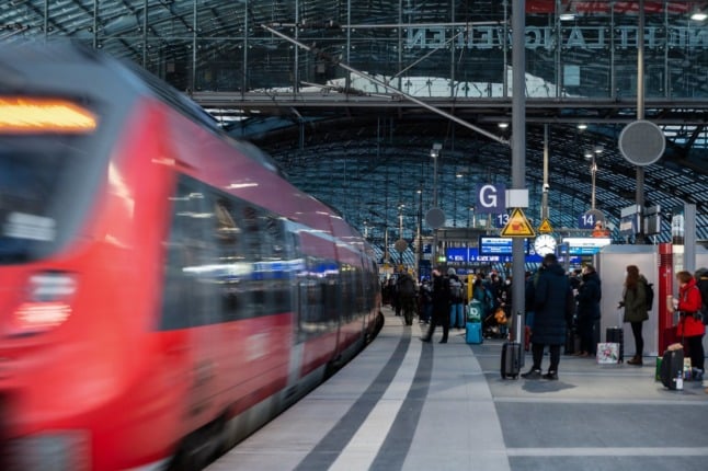 Passengers wait for a train at the Berlin main station.