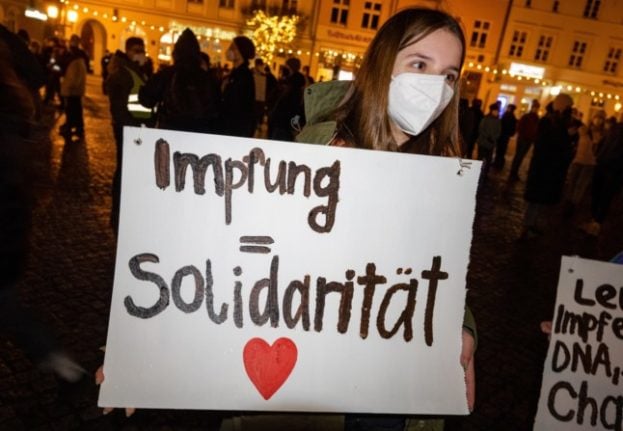 A pro-vaccine demonstrator holds a sign that says 'vaccination equals solidarity' in Greifswald, Mecklenburg-Western Pomerania 