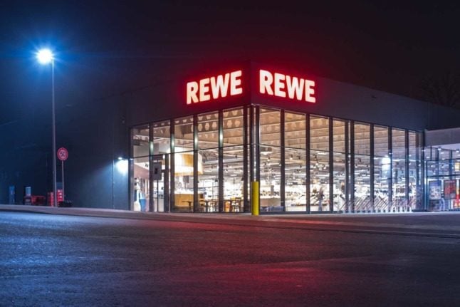 An outlet of German supermarket chain Rewe seen at night