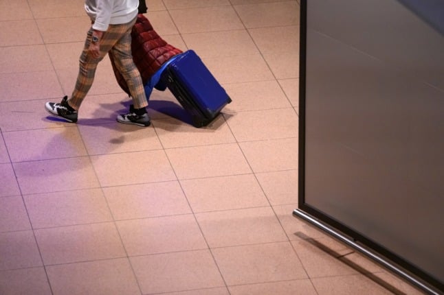 A traveller pulls a suitcase in Hamburg airport. 